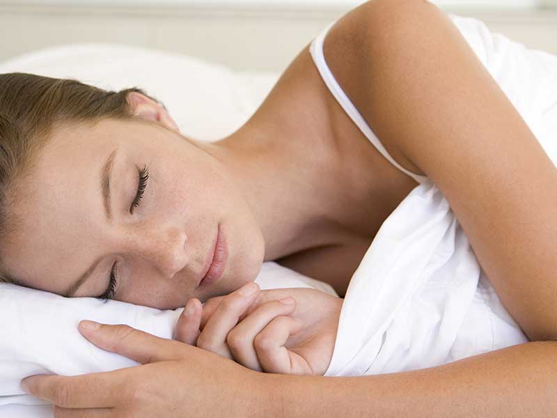 woman sleeping peacefully after her partners sleep apnoea treatment
